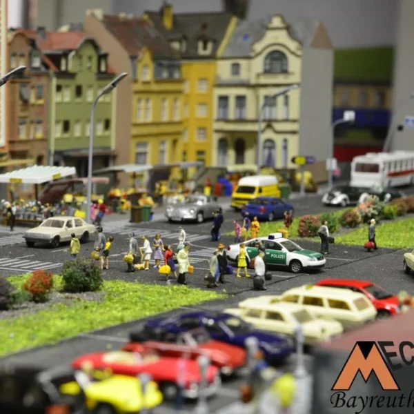 Auf dem Bahnhofsvorplatz sind typische Szenen einer Stadt zu sehen. Taxistand, Polizei, Busbahnhof, Wochenmarkt...