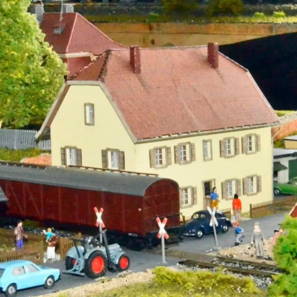 Szene mit viel Kleinod: reger Betrieb am Bahnübergang .